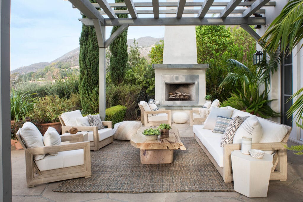 Outdoor patio and fireplace in a custom home Chatham featuring a cozy seating area and coastal design touches